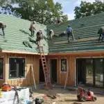 A cozy modern home under renovation, workers installing a new roof.